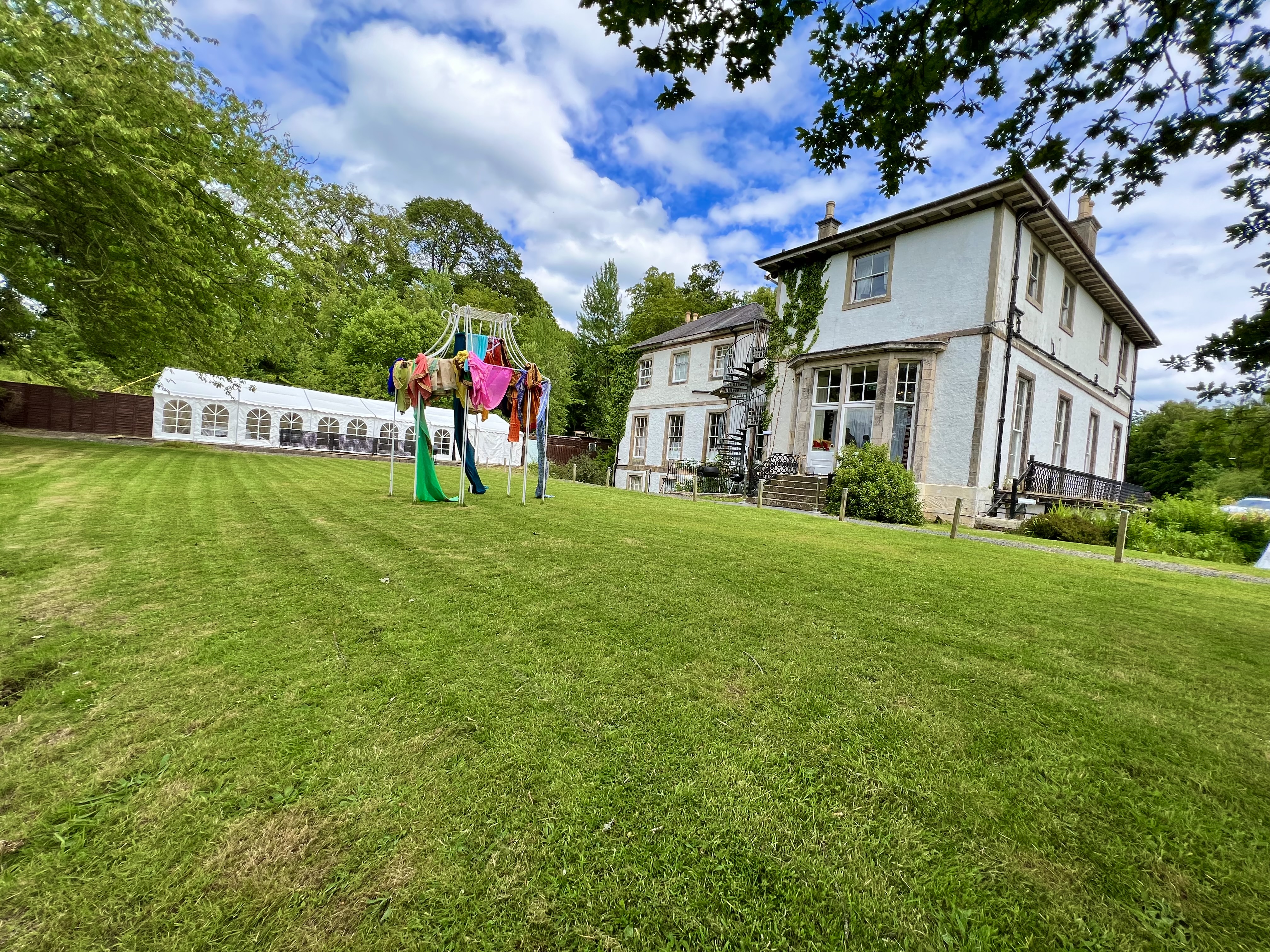 Rear grounds at Kirkhill Mansion with lawn, trees and event marquee